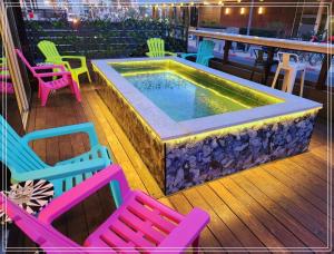 a pool sitting on a deck with colorful chairs at Dream Beach 98 Hotel And Spa - Affordable Seaside Choice 2025 in Tel Aviv