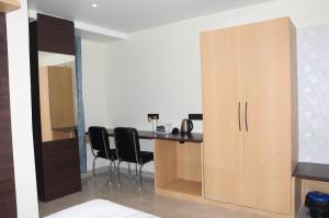 a kitchen with a desk and chairs in a room at FERN INN Kolkata in Kolkata