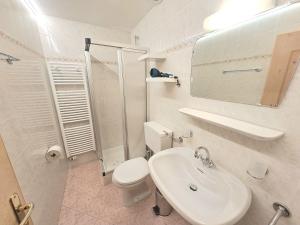 a white bathroom with a toilet and a sink at Ganoihof apartments in Funes