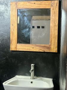 a bathroom sink with a mirror and a sink at Le Jardin Arhumatic in Sambava