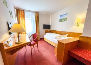 a hotel room with a bed and a desk at Hotel Restaurant Lamm Hebsack in Remshalden