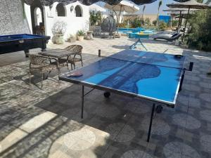 a ping pong table on a patio with a pool table at Encanto getaway in Sheikh Zayed