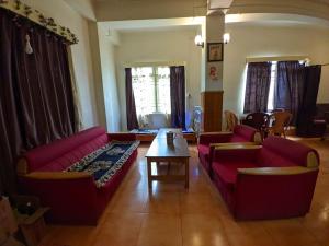 - un salon avec des canapés rouges et une table basse dans l'établissement Mangan Stone Pebbles Lodge, à Mangan
