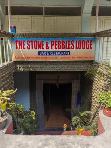 a sign for a store and pebbles lodge at Mangan Stone Pebbles Lodge in Mangan