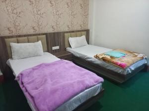 two beds sitting next to each other in a room at Mangan Stone Pebbles Lodge in Mangan