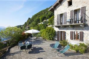 eine Terrasse mit Stühlen, einem Sonnenschirm und einem Gebäude in der Unterkunft La Terrazza in Carmine