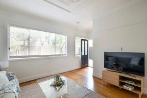 ein Wohnzimmer mit einem großen Flachbild-TV in der Unterkunft Inner city home West Footscray close to everything in Seddon