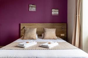 a purple bedroom with two towels on a bed at Le Bon Cap in Plurien