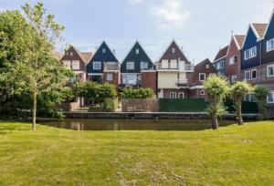a group of houses in a park next to a river at Volendam Lakeside Retreat - 20 min from Amsterdam in Volendam
