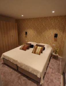 sypialnia z dużym białym łóżkiem z poduszkami w obiekcie Volendam Lakeside Retreat - 20 min from Amsterdam w mieście Volendam