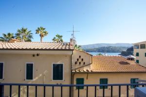 - Edificio con balcón con vistas al agua en Nel cuore di Porto Azzurro - Goelba, en Porto Azzurro
