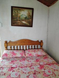 1 cama en un dormitorio con una foto en la pared en Thornton's Sea View Cafe & Guesthouse en Siquijor