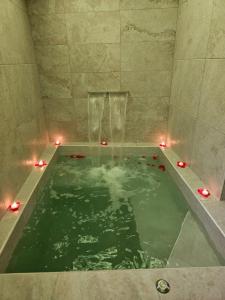 a bath tub filled with water with lights in it at LUXUITE SPA con PISCINA e JACUZZI in Alberobello