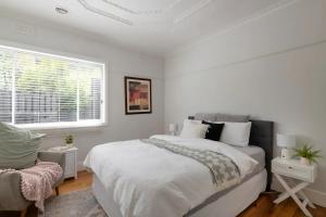 ein weißes Schlafzimmer mit einem großen Bett und einem Fenster in der Unterkunft Inner city home West Footscray close to everything in Seddon