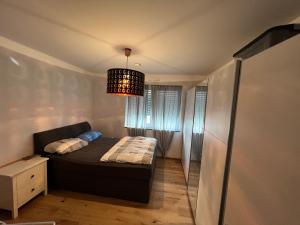 Habitación pequeña con cama y lámpara de araña. en Zentral & ruhig wohnen in Gießen, en Giessen