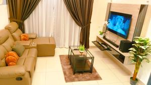 a living room with a couch and a tv at Kulai d'putra suites beside ioiMall near Airport and JPO in Kulai