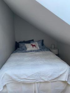 a bedroom with a white bed with a red x on it at Stuga Lotte in Billdal