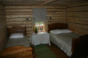 a bedroom with two beds and a table and a window at Anni Tourism Farm in Tammese