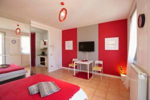 a bedroom with red walls and a bed and a tv at Residenz La Fonte Studios in Pino Lago Maggiore