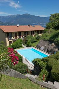 a house with a swimming pool in a yard at Residenz La Fonte Studios in Pino Lago Maggiore