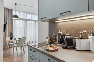 a kitchen with a counter and a table with chairs at Limehome Zwickau Magazinstr in Zwickau