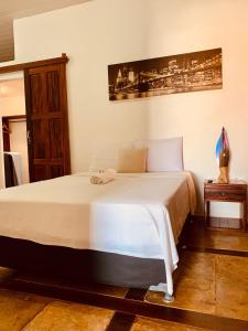 1 dormitorio con 1 cama blanca grande en una habitación en Pousada Casa do Bruno en Canoa Quebrada