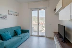 ein Wohnzimmer mit einem blauen Sofa und einem TV in der Unterkunft ligurian holidays sea view in San Bartolomeo al Mare