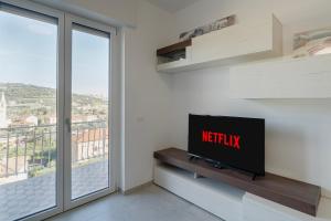 ein Wohnzimmer mit einem TV und einem großen Fenster in der Unterkunft ligurian holidays sea view in San Bartolomeo al Mare