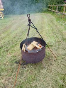a grill with sticks around it in a field at Romany Ri Campsite and Historic Wagon Site in Exeter