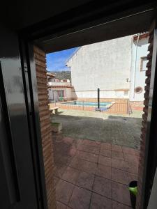 una puerta abierta a un patio con vistas a la piscina en los hubios, en Arroyo Frío