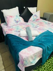 un letto con coperta e cuscini blu di Executive Guesthouse a Vereeniging