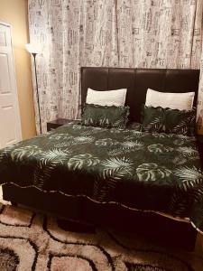 una camera da letto con un letto con un piumone e cuscini verdi di Executive Guesthouse a Vereeniging