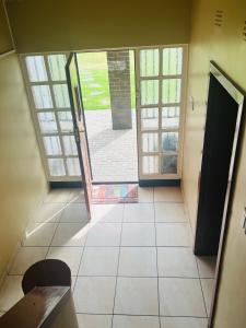 una porta aperta in una camera con pavimento piastrellato di Executive Guesthouse a Vereeniging