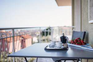 einen Tisch mit einem Tablett mit Erdbeeren und Kaffeetassen in der Unterkunft ligurian holidays sea view in San Bartolomeo al Mare