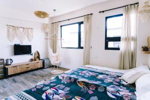 1 dormitorio con 1 cama, TV y ventanas en 禾田遇民宿 Hetianyu, en Sanxing