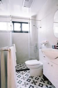 a white bathroom with a toilet and a sink at 禾田遇民宿 Hetianyu in Sanxing