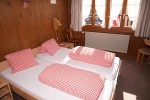ein Bett mit vier roten und weißen Kissen darauf in der Unterkunft Gasthaus zum Sternen in Andermatt