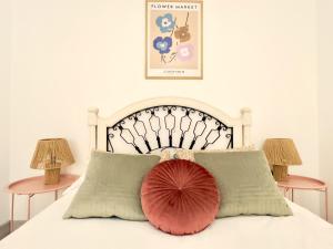 a white bed with a red pillow on it at Housingleón Cardiles I y II in León