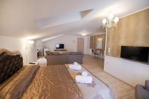 a bedroom with a large bed and a living room at SUITES PIROFANI in Lefkada