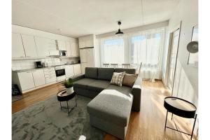 a living room with a couch and a table at Kotimaailma Apartments Oulu in Oulu