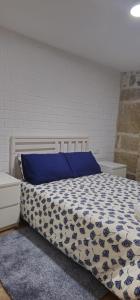 um quarto com uma cama com um edredão azul e branco em Casa Gil - AL em Valença
