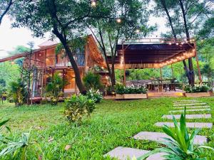 a house in the middle of a yard with a patio at Căn Bali (Moon Villa Sóc Sơn) in Hanoi