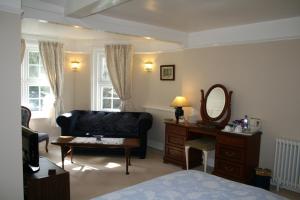 リンドハーストにあるClayhill House Bed & Breakfastのソファ、テーブル、鏡付きのベッドルーム1室が備わります。