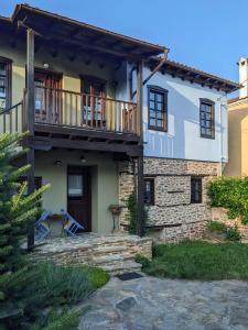 a house with a balcony and a patio at Melina Hotel - Heritage in Polygryos