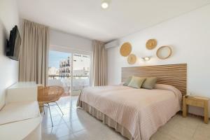 サンタ・エウラリア・デス・リウにあるazuLine Hotel Mediterráneoのベッドルーム(ベッド1台付)、バルコニーが備わります。
