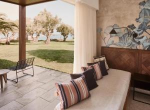 a living room with a couch and a large window at Phāea Cretan Malia, a Member of Design Hotels in Malia +119 photos