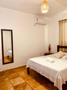 een slaapkamer met een bed en een spiegel bij Pousada Casa do Bruno in Canoa Quebrada
