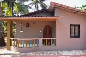 ein kleines Haus mit einer Veranda und einem Balkon in der Unterkunft Valerys Nest Bogmalo - Private villa near the beach and Dabolim airport in Bogmalo Beach