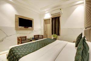 Hotel International Inn by Star group - Near Delhi Airport في نيودلهي: غرفة فندق بسرير وتلفزيون