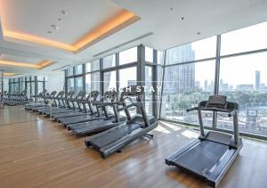 a gym with a row of treadmills and windows at Superb 1BR at Burj Vista In Downtown Dubai in Dubai